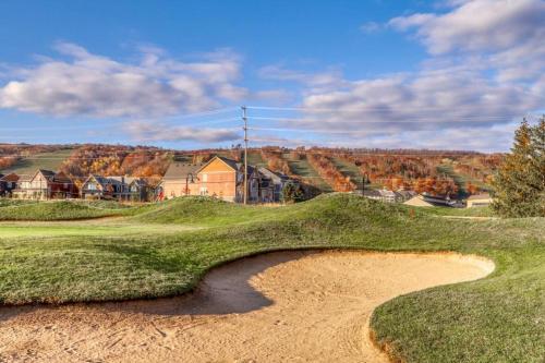 a bunker on a golf course with a hill in the background at Chateau Ridge in Blue Mountains