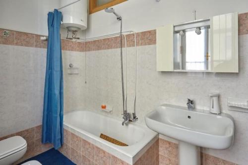 un bagno con vasca, lavandino e WC di La Casa Accanto 32 a Brescia