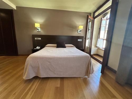 a bedroom with a bed with a white bedspread at Hotel Baltico in Luarca