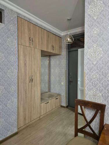 a kitchen with wooden cabinets and a chair in a room at gegidze 24 in Poti