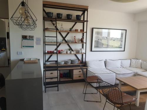 a living room with a white couch and a table at Departamento con vista al Golf Barrio Costa Esmeralda in Costa Esmeralda