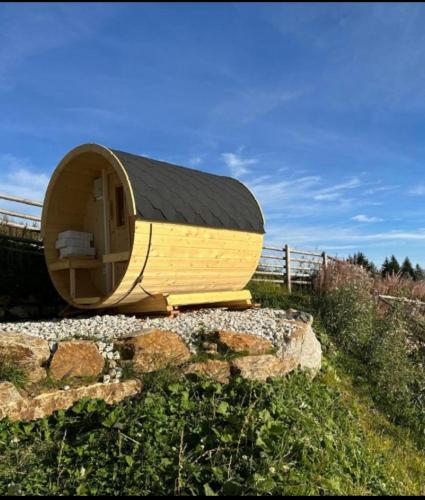 a wooden dog house sitting on top of some rocks at Appartement Weitblick in Klippitztorl