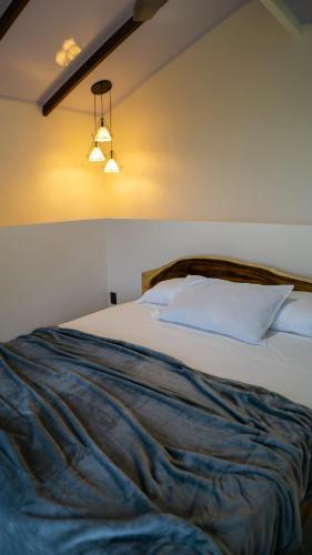 a bedroom with a bed with a blue blanket at Divan Eco Lodge in Fortuna