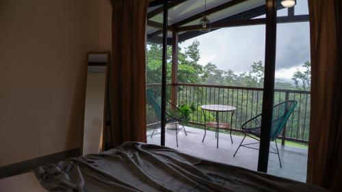 a bedroom with a balcony with a table and chairs at Divan Eco Lodge in Fortuna