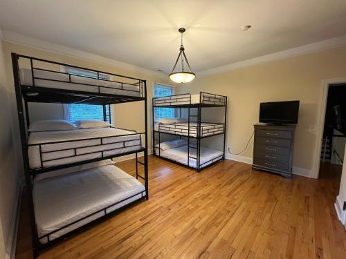 a room with three bunk beds and a television at Beautiful River front home with private pool in Phillipsburg