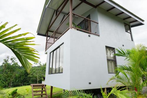 a white house with a balcony on top of it at Divan Eco Lodge in Fortuna