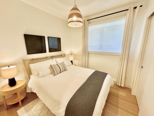 una camera da letto con un grande letto bianco e una finestra di Central Moodyville Retreat a North Vancouver