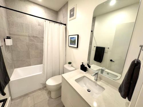 un bagno bianco con lavandino e WC di Central Moodyville Retreat a North Vancouver