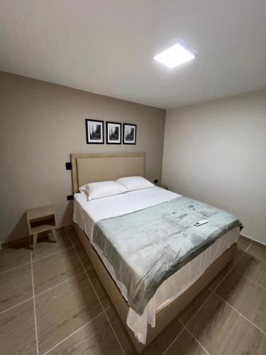 a bedroom with a large bed with three pictures on the wall at Laureles Inn in América