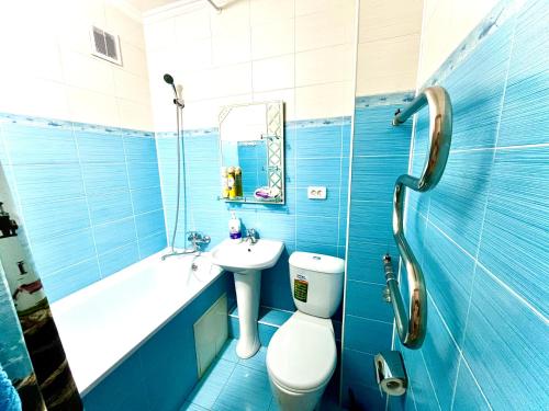 a blue bathroom with a toilet and a sink at Квартиры посуточно Талдыкорган in Taldykorgan