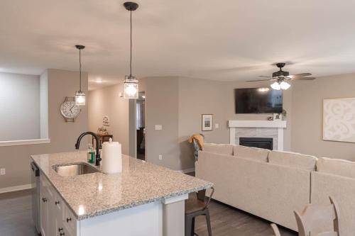 a kitchen and living room with a sink and a couch at Brand New 2 Bedroom with Office in Loves Park