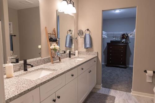 a bathroom with two sinks and a large mirror at Brand New 2 Bedroom with Office in Loves Park