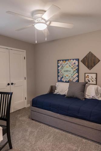 a bedroom with a blue bed and a ceiling fan at Brand New 2 Bed with Office in Loves Park