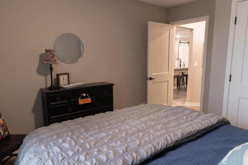 a bedroom with a bed and a dresser and a mirror at Brand New 2 Bed with Office in Loves Park
