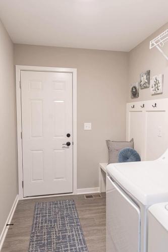 a white kitchen with a white door and a sink at Brand New 2 Bed with Office in Loves Park