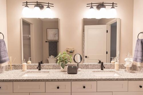 a bathroom with two sinks and two mirrors at Brand New 2 Bed with Office in Loves Park