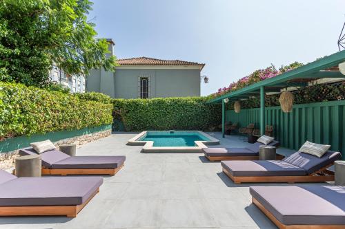 a patio with lounge chairs and a swimming pool at Arrábida Guest House in Setúbal