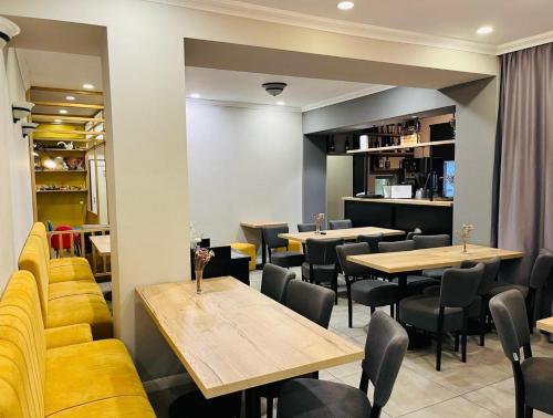 a restaurant with tables and chairs and a kitchen at Pensiunea Ana Maria in Baile Felix