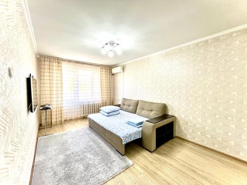 a living room with a bed and a couch at Квартиры посуточно Талдыкорган in Taldykorgan