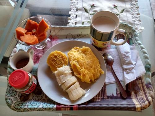 a plate of breakfast food with fruit and a cup of coffee at Hostal Finca San Martín De Loba in Los Naranjos