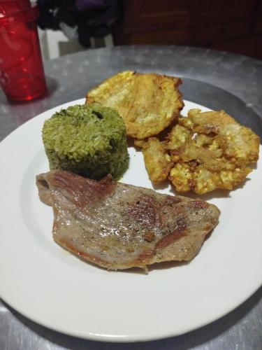 a plate of food with meat and broccoli on a table at Hostal Finca San Martín De Loba in Los Naranjos