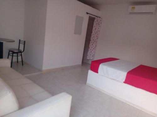 a room with a bed and a chair in it at Hostal Finca San Martín De Loba in Los Naranjos