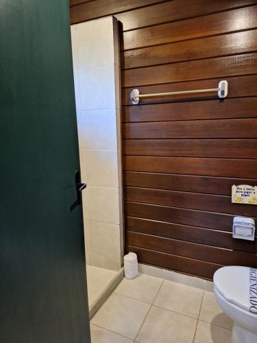 a bathroom with a wooden door and a toilet at Urikana Boutique Hotel in Teresópolis