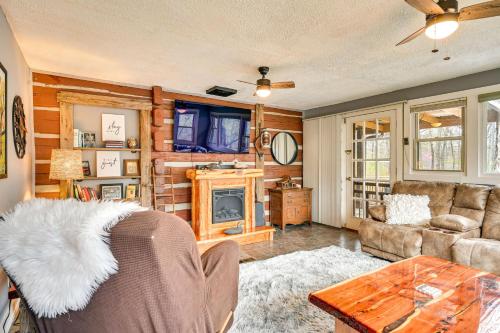 a living room with a couch and a fireplace at Country Escape Log Cabin Near Kentucky Lake! in Gilbertsville