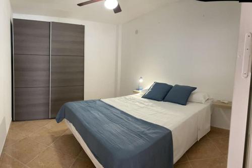 una camera da letto con un letto grande con cuscini blu di Neruka House a Torremolinos
