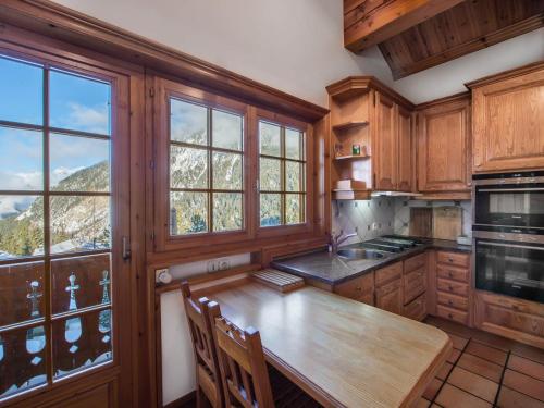 une cuisine avec des armoires en bois et une table en bois dans l'établissement Chalet savoyard de caractère avec sauna et cheminée à Courchevel 1650 - FR-1-563-17, à Courchevel