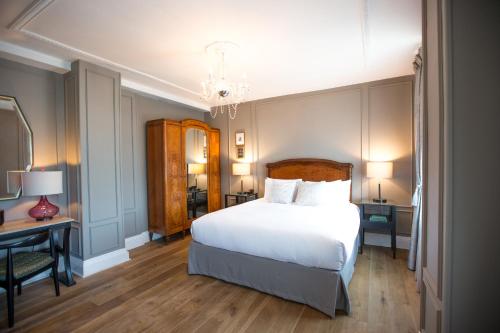 a bedroom with a large white bed and a desk at The Culver Hotel in Los Angeles