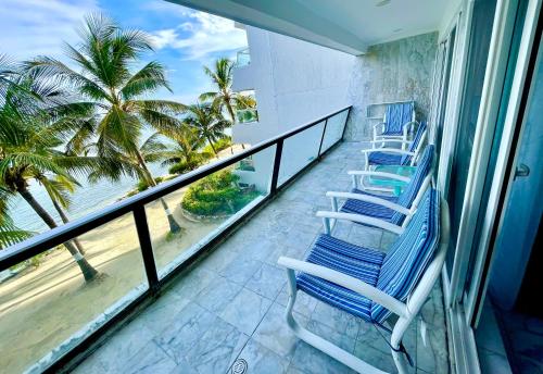 a balcony with blue chairs and a view of the ocean at Exclusivos Apartamentos con playa privada in San Andrés