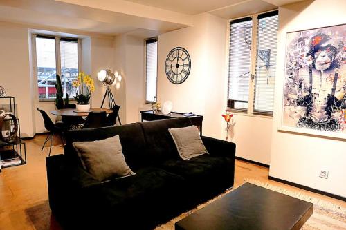 - un salon avec un canapé noir et un réveil dans l'établissement Appart chic vieux nice 3 min de la plage, à Nice