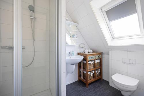 un baño con inodoro y lavabo en Sandkorn-Büsum, en Büsum