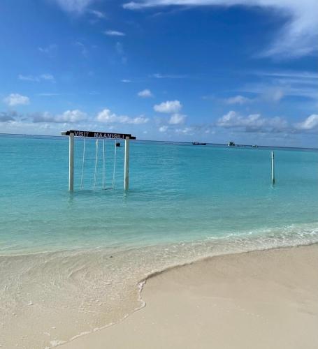 a building in the water on a beach at Koimala Hotel in Maamigili