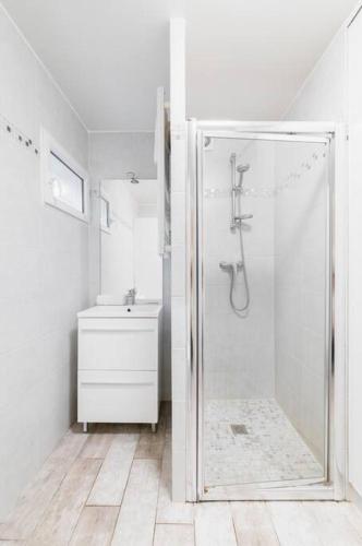 une salle de bain blanche avec une douche et un lavabo dans l'établissement Studio Confortable proche métro - Saint mandé, à Saint-Mandé