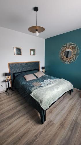 une chambre avec un lit et un mur bleu dans l'établissement Le Domaine Vesque. Le LOFT, à Saint-Pierre-de-Clairac