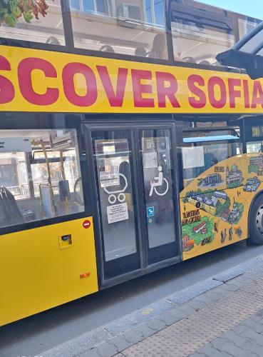 a yellow bus with a sign on the side of it at Central Apartment 2 in Sofia