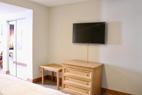 a room with a dresser and a flat screen tv on the wall at Walk To Mountain Base Studio For 4 & Pool in Crested Butte
