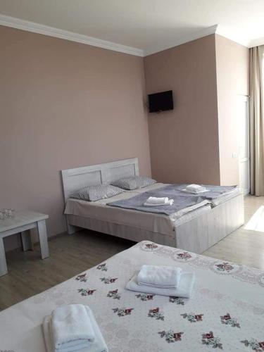 a bedroom with a bed and a table with towels at Hotel Like Mari in P'ichvnari