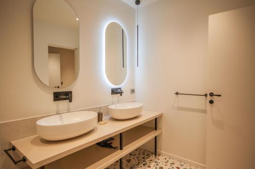 a bathroom with two sinks and two mirrors at cvm 19 in Milan