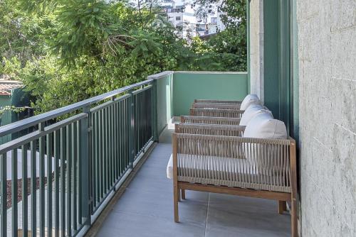 a row of benches sitting on a balcony at Arrábida Guest House in Setúbal