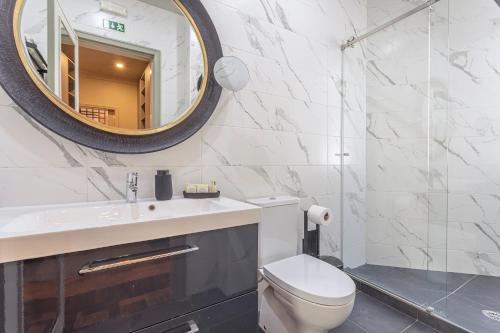 a bathroom with a toilet and a mirror at Arrábida Guest House in Setúbal