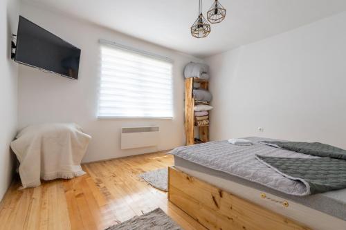 a bedroom with a bed and a flat screen tv at Aleks apartmani in Knjazevac.