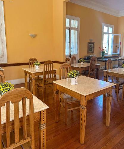 a dining room with wooden tables and chairs at Pousada Crystal Palace in Petrópolis