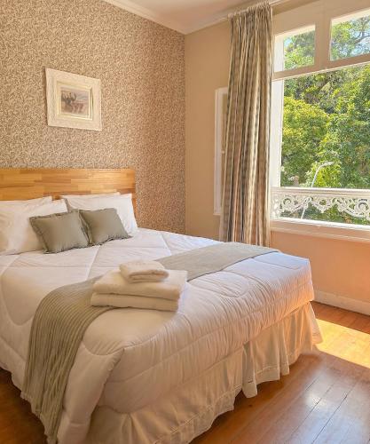 a bedroom with a bed with towels on it at Pousada Crystal Palace in Petrópolis