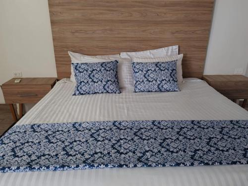 a bed with blue and white sheets and pillows at Hotel Flamingo in Ciudad Juárez