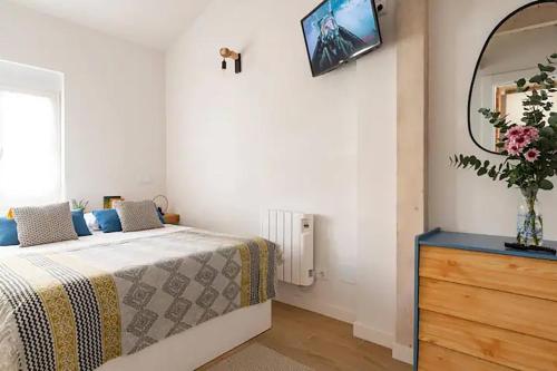 a bedroom with a bed with a dresser and a mirror at Loft con amplia terraza en el centro de Santander in Santander