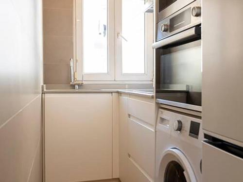 a kitchen with a microwave and a washer and dryer at Loft con amplia terraza en el centro de Santander in Santander