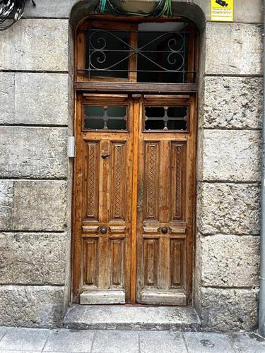 a wooden door in a stone building with a window at Loft con amplia terraza en el centro de Santander in Santander